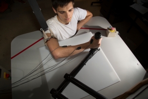 Graduate student James Hermus demonstrates a production robot based on the original MIT-MANUS design in the Eric P. and Evelyn E. Newman Laboratory for Biomechanics and Human Rehabilitation. The robot, which helps stroke victims recover and regain mobility, represents one of the many ways MIT's mechanical engineering researchers are working to improve health care. Photo: John Freidah