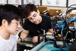 02/23/19 E-15 Sang-won Leigh PhD '18, left, works with second-year student Ethan Nevidomsky, an electrical engineering and computer science major, on ArtMatr’s oil-based printing system during the Computing Connections Challenges. Sang Leigh (left) and Ethan Nevigomsky controls their Artmatr robotic painting system to paint a portrait on plexiglass on Saturday, February 23, 2019. Photo by Jake Belcher http://news.mit.edu/2019/schwarzman-college-student-computing-challenge-0226