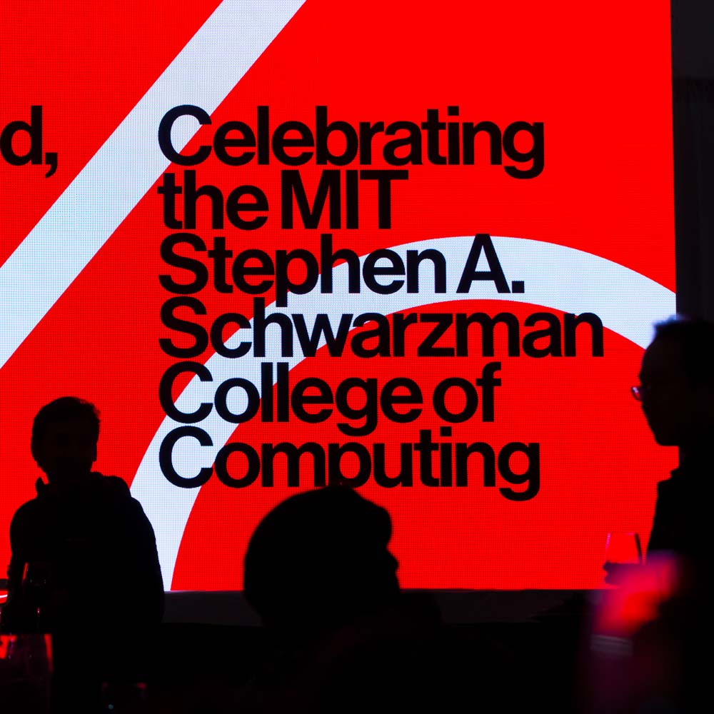 Image of a screen with black text on a red background during the inaugural event launching the College of Computing.