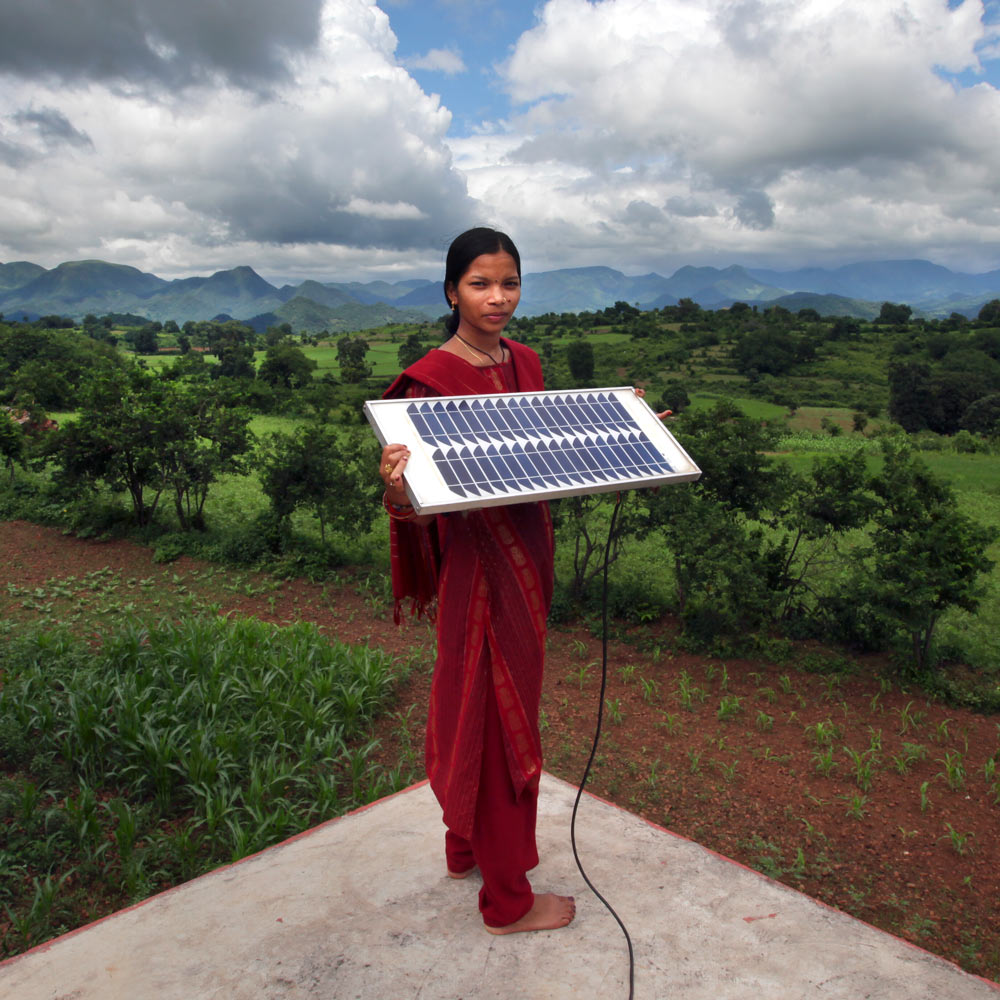 Woman from a rural part of India holds a solar panel.