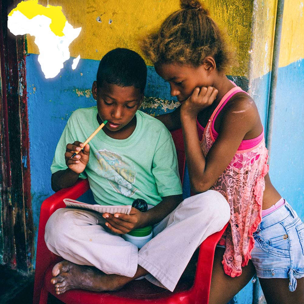 Image of two youths studying a booklet.