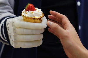 Robotic gloved hand holding a cupcake