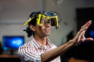 A man wears a virtual reality headset with his arm extended forward