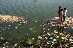Children playing near dirty water littered with trash. Near the Palace in Jaipur India.